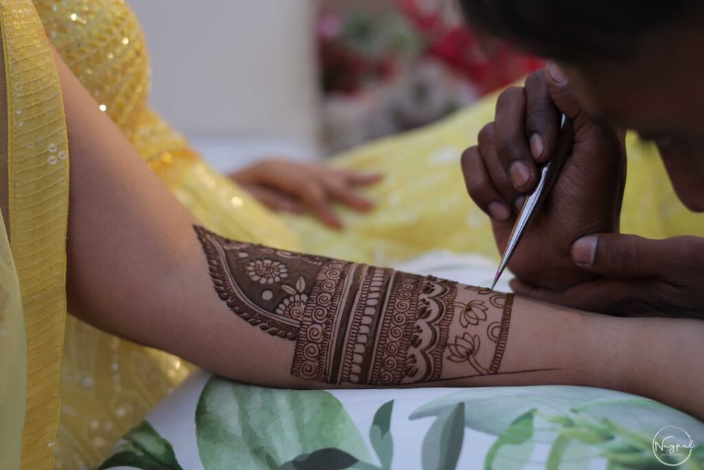 Bride getting her mehandi done by henna artist.