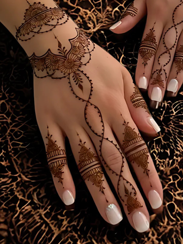 Intricate bridal Mehndi design on the back of the hand featuring a large circular mandala pattern connected to the wrist with dotted chains, and symmetrical scalloped motifs extending over the fingers