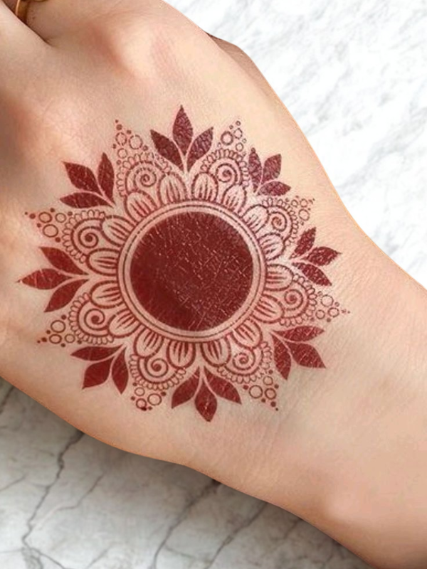 Intricate Mehndi design on the palm featuring a large central mandala with a butterfly motif, surrounded by fine floral and paisley patterns, with additional small butterfly and geometric accents on the fingers and wrist.
