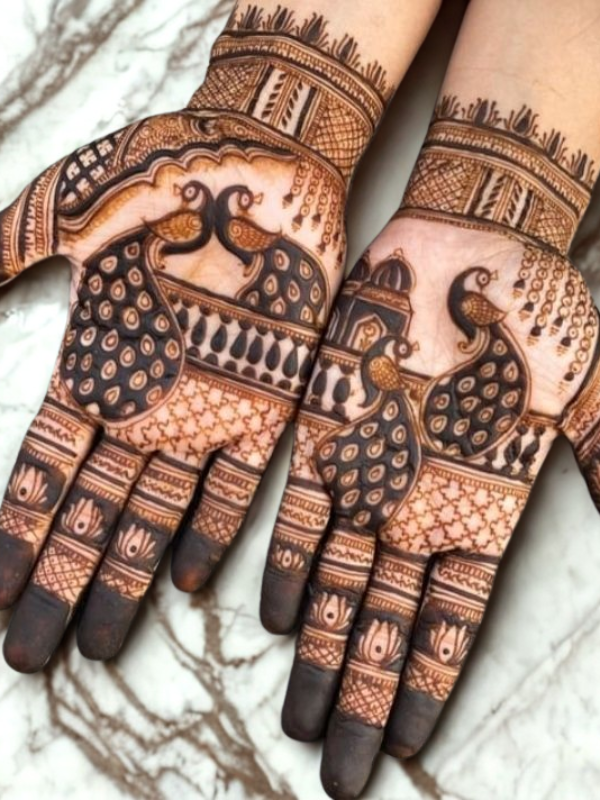 Bridal hands adorned with intricate Kalash-themed Mehndi design featuring traditional pot motifs, floral patterns, and detailed linework on the palms and fingers